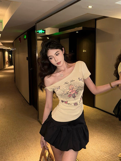 NA+ 嘻痞辣妹十字愛心印花不規則斜肩上衣 黑/卡其